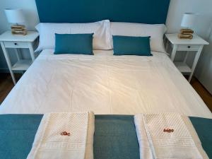 duże białe łóżko z 2 szafkami nocnymi i 2 poduszkami w obiekcie VoraMar 3 Playa Puerto de Sagunto w mieście Sagunto