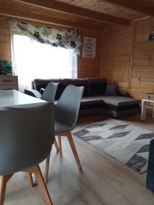 uma sala de estar com um sofá, uma mesa e cadeiras em Sielanka na wzgórzu em Czostków