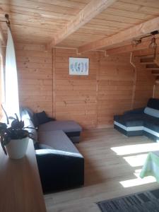 una sala de estar con sofá y escaleras en una cabaña en Sielanka na wzgórzu, en Czostków
