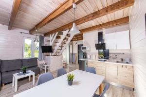 a kitchen and living room in a tiny house at Domki przy Mysliwskiej in Grzybowo