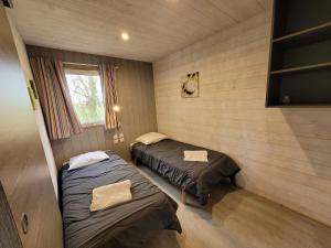 a room with two beds in a room with a window at Camping la Venise Verte in Coulon
