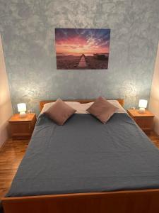 Apartments Denis & Lucija في روفينج: غرفة نوم بسرير كبير مع مواقف ليلتين