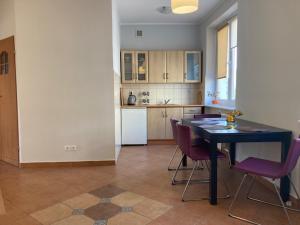 a kitchen with a table and chairs in a room at Apartament Turkus in Gdynia +3 photos