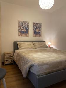 a bedroom with a bed with three paintings on the wall at Nel Borgo in Verrès