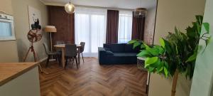 sala de estar con sofá azul y mesa en Mazovia Gold Apartament 101, en Płock