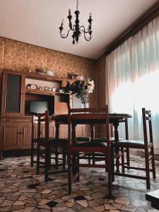 een eetkamer met een tafel en stoelen en een kroonluchter bij Milkyway Apartment in Viareggio
