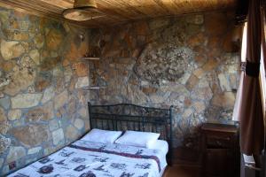 a bedroom with a stone wall with a bed at Uysallar Koy Evi in Gokceada Town +56 photos