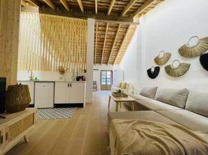 a living room with a couch and a kitchen at Loft Albufera in Valencia