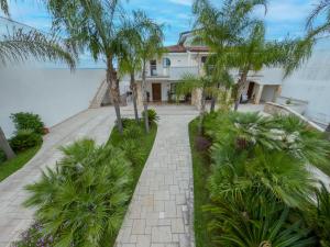 a walkway in front of a house with palm trees at Villa Silvana in Lecce