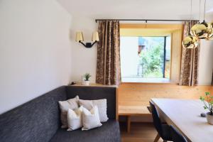 ein Wohnzimmer mit einem Sofa und einem Tisch in der Unterkunft Bio Apartment - Der Steinadler in Umhausen