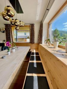 Zimmer mit einem langen Holztisch und einem großen Fenster in der Unterkunft Bio Apartment - Der Steinadler in Umhausen
