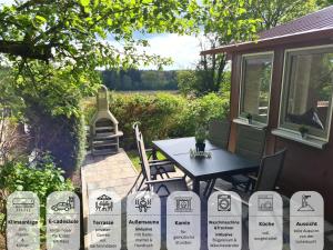 een patio met een tafel en stoelen voor een huis bij Ferienhaus Rothsee-Oase ideale Ausgangslage mit tollem Ausblick, Sauna und privatem Garten in Roth