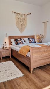 a large wooden bed in a room with wooden floors at Apartamenty U Pana Jana in Wetlina