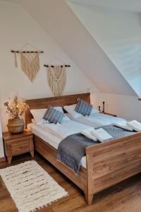 a bedroom with a large wooden bed with blue pillows at Apartamenty U Pana Jana in Wetlina