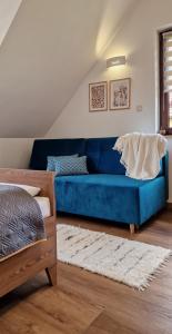 a blue couch in a living room with a bed at Apartamenty U Pana Jana in Wetlina