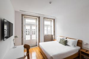 um pequeno quarto com duas camas e uma televisão em Avenida Viana Boutique Suites em Viana do Castelo