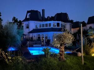 ein großes weißes Haus mit einem Pool davor in der Unterkunft Villa Fallingstar in Bad Saarow