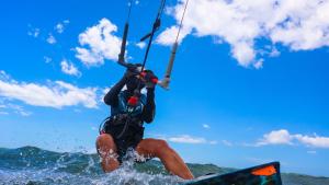 a man in the water holding on to a parachute at Pousada Movimento in Prea