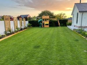 a backyard with a lawn with a house and a play implement at Luxury Devon House in Chulmleigh