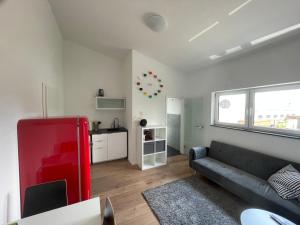 a living room with a couch and a red refrigerator at Ferienwohnung OLA in Schwanau