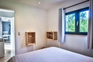 een slaapkamer met een bed en een raam bij Tinyhouses - Domain "La vallée des Prés" in Bande