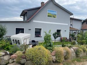 une maison blanche avec un panneau dans un jardin dans l'établissement Ferienwohnung Fiene, à Groß Zicker