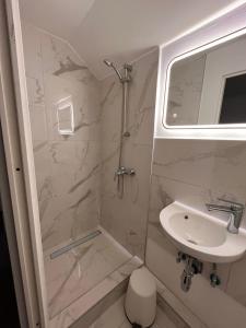 ein kleines Badezimmer mit Waschbecken und Dusche in der Unterkunft Ein schönes Zimmer in Kiel in Kiel