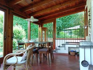 a dining room with a table and chairs on a porch at Villetta con giardino a due passi dal mare in Imperia