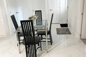 uma sala de jantar com uma mesa de vidro e cadeiras em Stylish and luxurious apartment basement unit em Longueuil