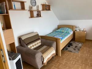 a small bedroom with a bed and a chair at Apartment mit Blick auf Herkules mit Parkplatz in Kassel