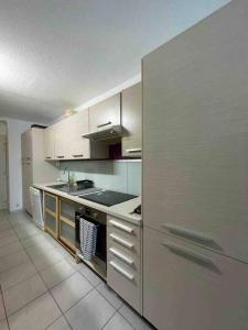 Grosseto-PrugnaAppartement cosy, vue mer à 5 min à pied de la mer的配有白色橱柜和不锈钢冰箱的厨房 更多17张照片