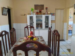 une cuisine avec une table, des chaises et des fruits. dans l'établissement Icaraí Atlantic Village, à Caucaia