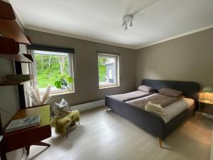 a bedroom with a bed and two windows at Charming apartment in Ålesund center with free parking in Ålesund