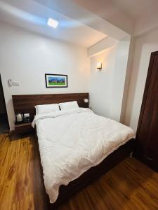 um quarto com uma cama grande e lençóis brancos em Ivanna stay em Patan