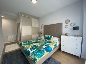 a bedroom with a large bed and a dresser with a bed sidx sidx sidx at Apartamentos modernos Residencial el Pinar in Liencres
