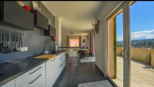 une grande cuisine avec vue sur un balcon dans l'établissement Chez Pasqua ! Appartement spacieux avec terrasse 2 chambres 6 couchages en Rooftop, à LʼÎle-Rousse