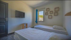 um quarto com 2 camas, uma televisão e uma janela em Chez Pasqua ! Appartement spacieux avec terrasse 2 chambres 6 couchages en Rooftop em L'Île-Rousse