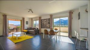 un salon avec une table, des chaises et un canapé dans l'établissement Chez Pasqua ! Appartement spacieux avec terrasse 2 chambres 6 couchages en Rooftop, à LʼÎle-Rousse