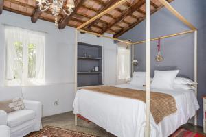 um quarto com uma cama de dossel e um sofá branco em Le Rondini- Solo Adultos em Montrás