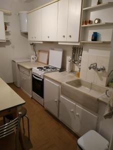 アテネにあるNicole Apartmentのキッチン(白いキャビネット、コンロ、シンク付)