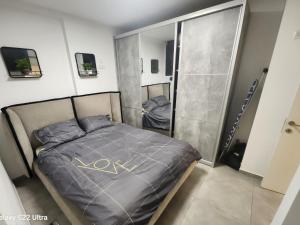 a small bedroom with a bed and a shower at The Kingdom On The Beach in Bat Yam