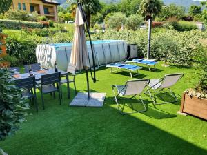een patio met een tafel, een parasol en stoelen bij A Due Passi dal Lago in Colico