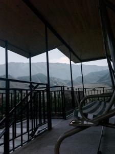 a chair on a balcony with a view of mountains at M7 House in Gorists'ikhe