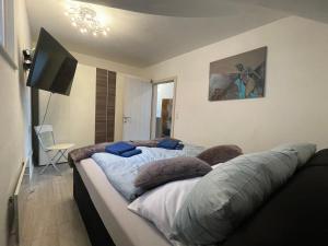 a bedroom with two beds with pillows and a flat screen tv at Ferienwohnung am Seeblick in Feldkirchen in Kärnten