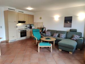 un soggiorno con un divano, un tavolo e una cucina di Apartment Biber mit Terrasse a Dewichow Altre 13 foto