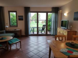 a living room with a tv and a table and chairs at Apartment Biber in Dewichow