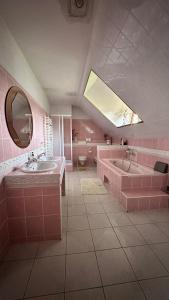 a pink bathroom with two sinks and a mirror at Zielone Zarabie Residence in Myślenice