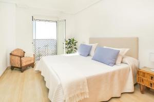a bedroom with a large white bed with blue pillows at Ático Almería. Paseo marítimo Roquetas de Mar in Roquetas de Mar +33 photos