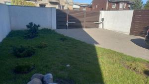 a yard with a fence and a driveway at the holiday house in Klaipėda