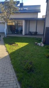 a backyard with a lawn with a picnic table in it at the holiday house in Klaipėda